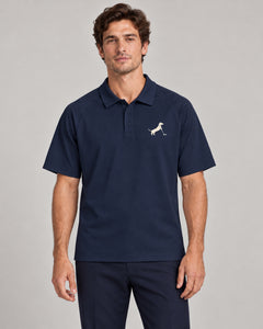 Man wearing Putting dachshund golf polo, front studio view. Color: Navy Blue