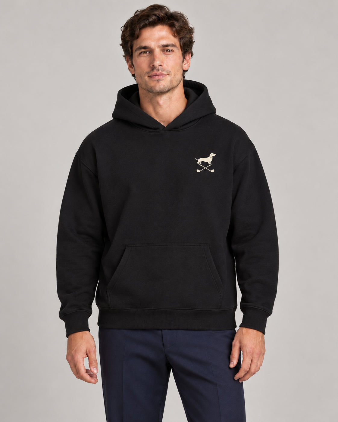 Man wearing Club & Swing dachshund golf hoodie, front studio view. Color: Black