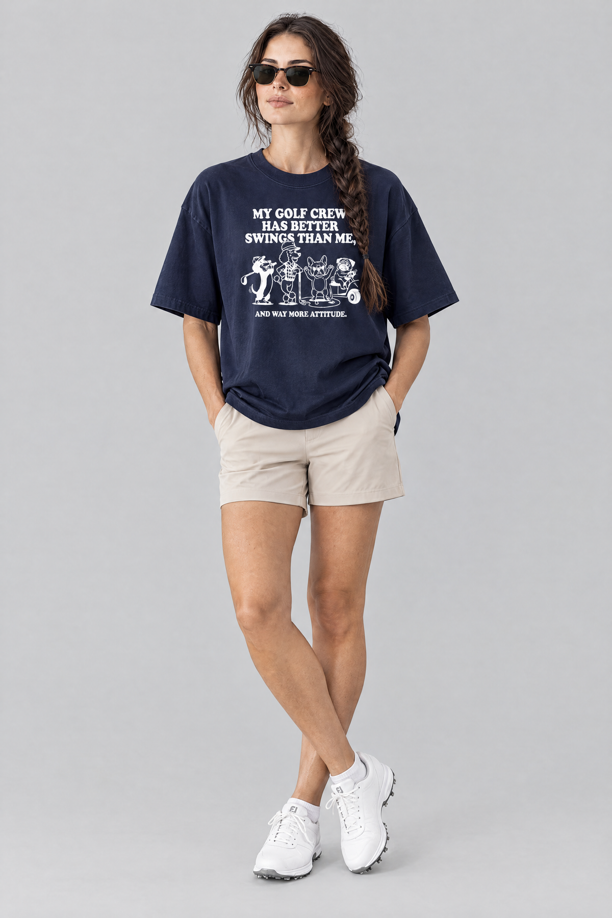 Woman wearing the Better Swings Dog Golf Tee in navy with beige golf shorts and sunglasses. Color: Navy