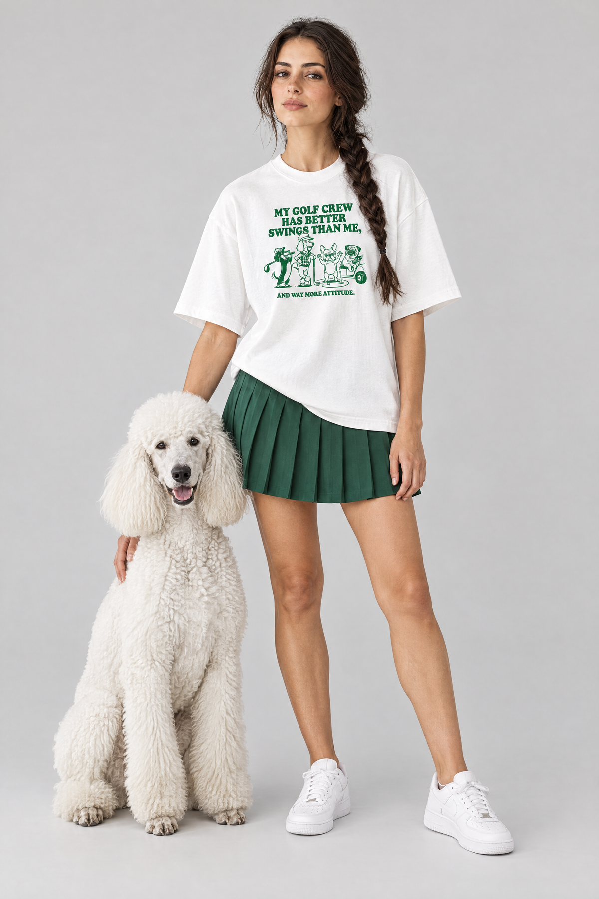 Woman wearing the Better Swings Dog Golf Tee in white with a white standard poodle. Color: White