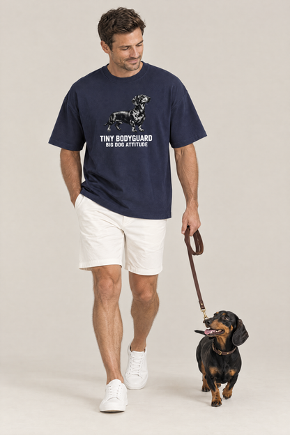 Man walking a black and tan dachshund on a leash in the navy Big Dog Attitude Dachshund Tee. Color: Navy