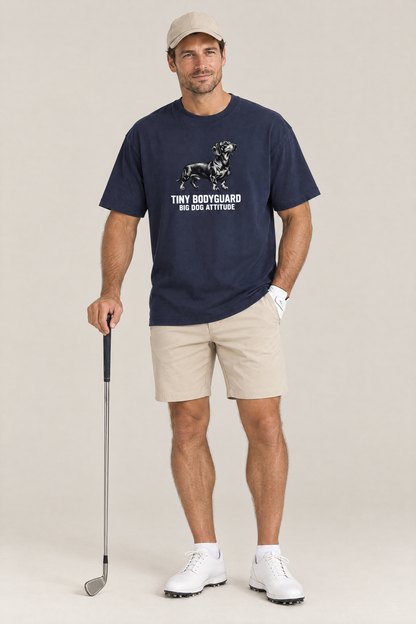 Man in a beige cap holding a golf club in the navy Big Dog Attitude Dachshund Tee. Color: Navy