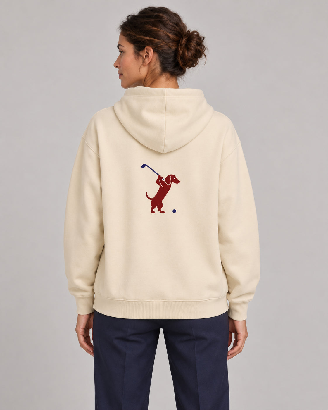 Woman wearing Club & Swing dachshund golf hoodie, back studio view. Color: Apricot