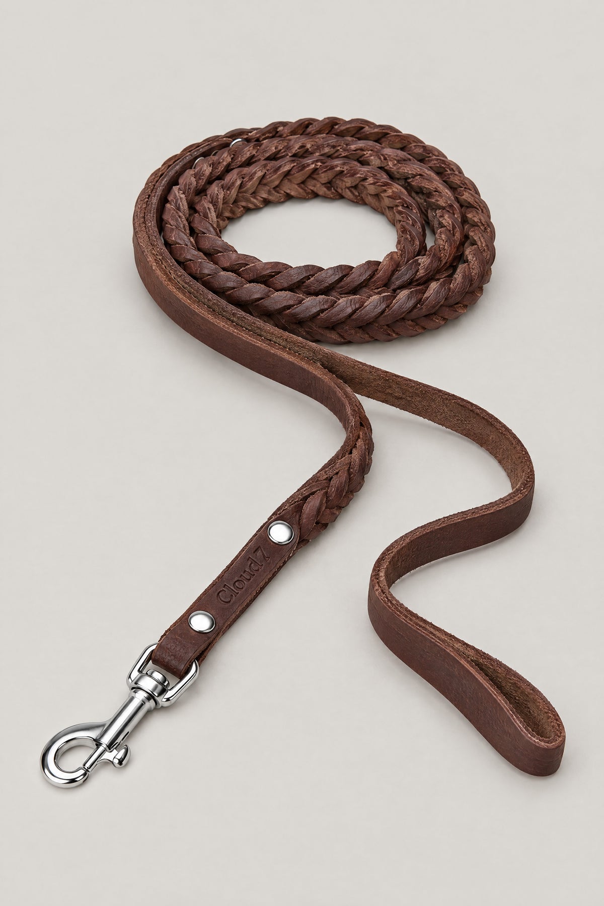 Saddle brown braided leather Cloud 7 Central Park dog leash with hand loop and stainless steel snap hook, coiled front view