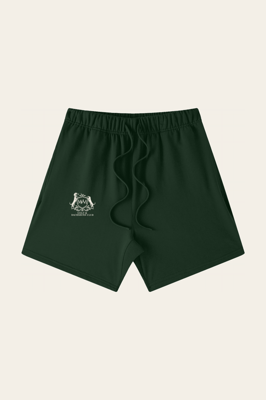 Flat lay of blackish green Club Crest shorts with the small cream Golf & Dachshund Club crest on the leg, front view. Color: Blackish Green
