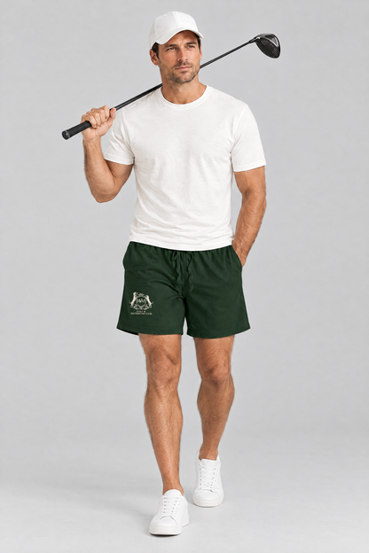 Man walking with a driver over his shoulder in blackish green Club Crest shorts, a white tee and a white cap. Color: Blackish Green