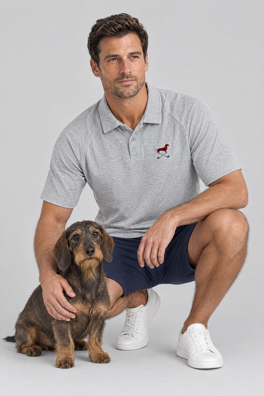 Man crouching next to a wire-haired dachshund in the flower gray Club Mark dachshund golf polo and navy golf shorts. Color: Flower Gray