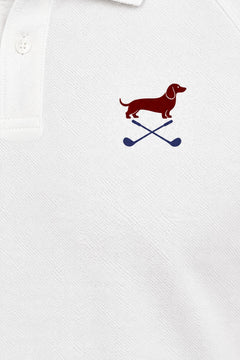 Close-up of the collar and chest logo on the white Club Mark dachshund golf polo. Color: White