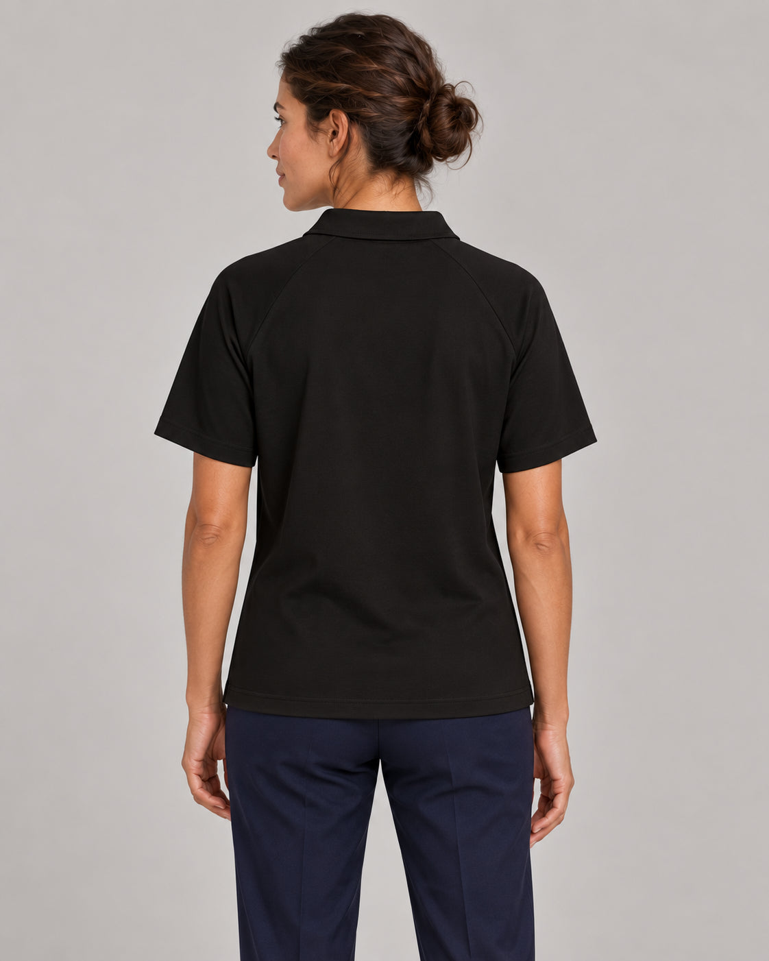 Woman wearing Putting dachshund golf polo, back studio view. Color: Black