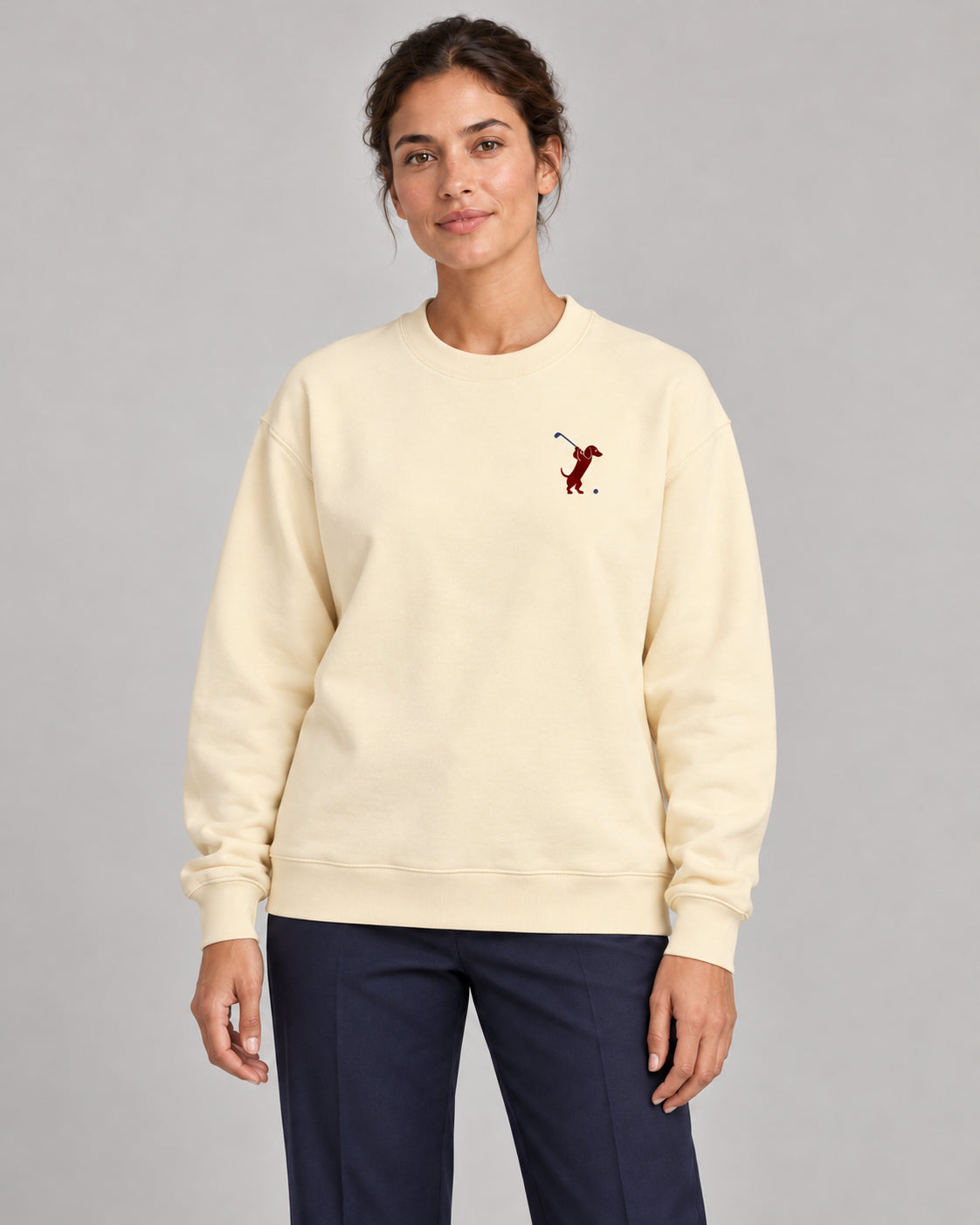 Woman wearing Swing dachshund golf sweatshirt, front studio view. Color: Apricot