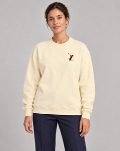 Woman wearing Swing dachshund golf sweatshirt, front studio view. Color: Apricot