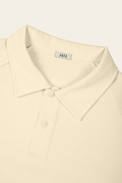 Close-up of the collar and two-button placket of the apricot golf polo with the MVM woven neck label. Color: Apricot