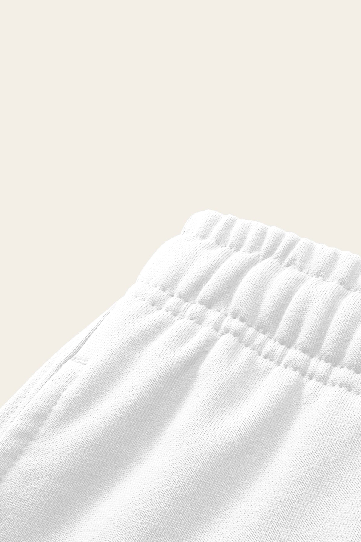 Detail of the elastic waistband and side pocket of the white golf sweatpants. Color: White