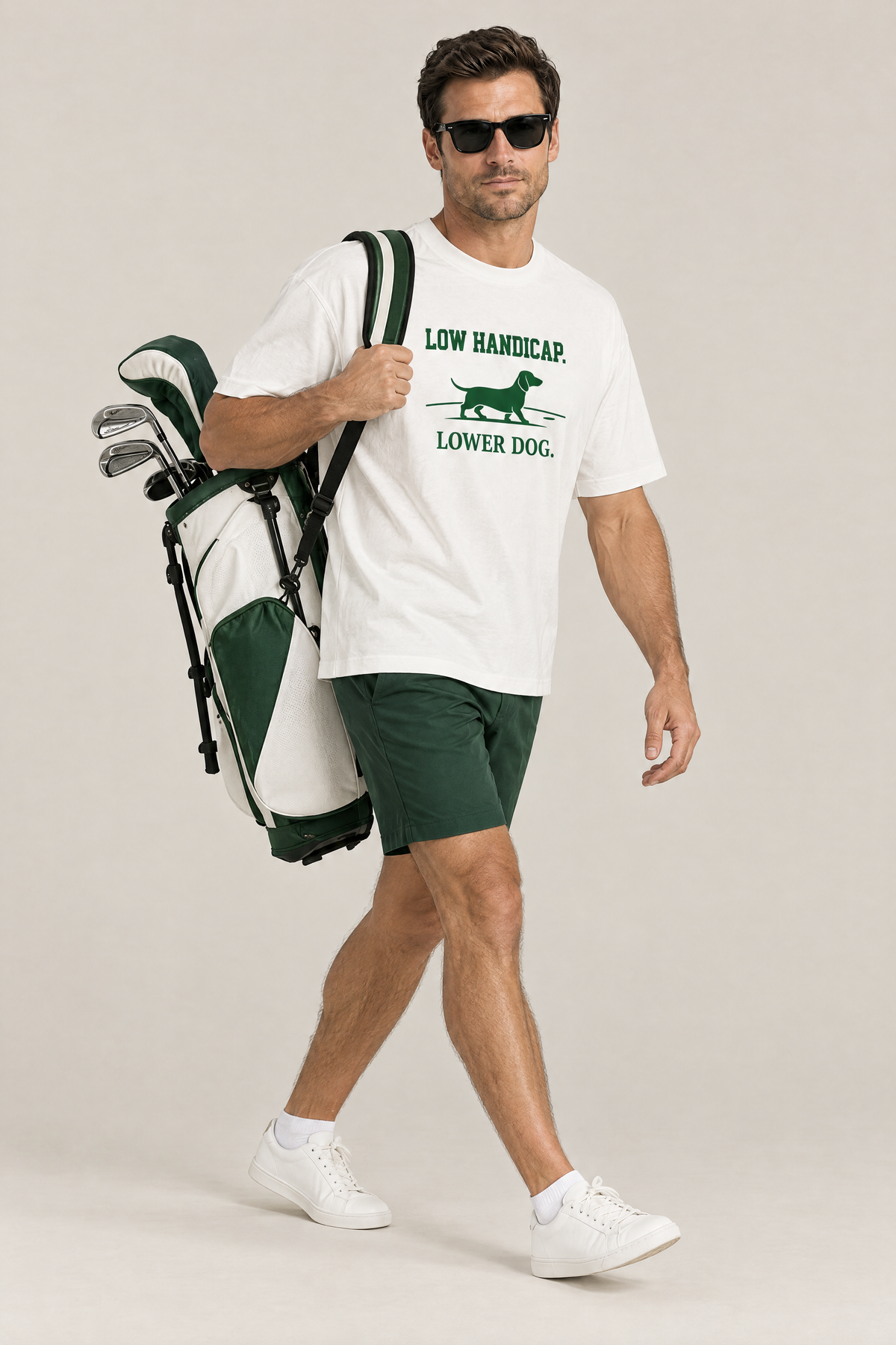 Man carrying a golf bag in the white Low Handicap Dachshund Golf Tee. Color: White