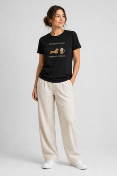 Woman wearing a black t-shirt with a graphic design on a plain background