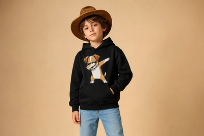 Child wearing a black hoodie with a dog graphic, blue jeans, and a brown hat on a beige background