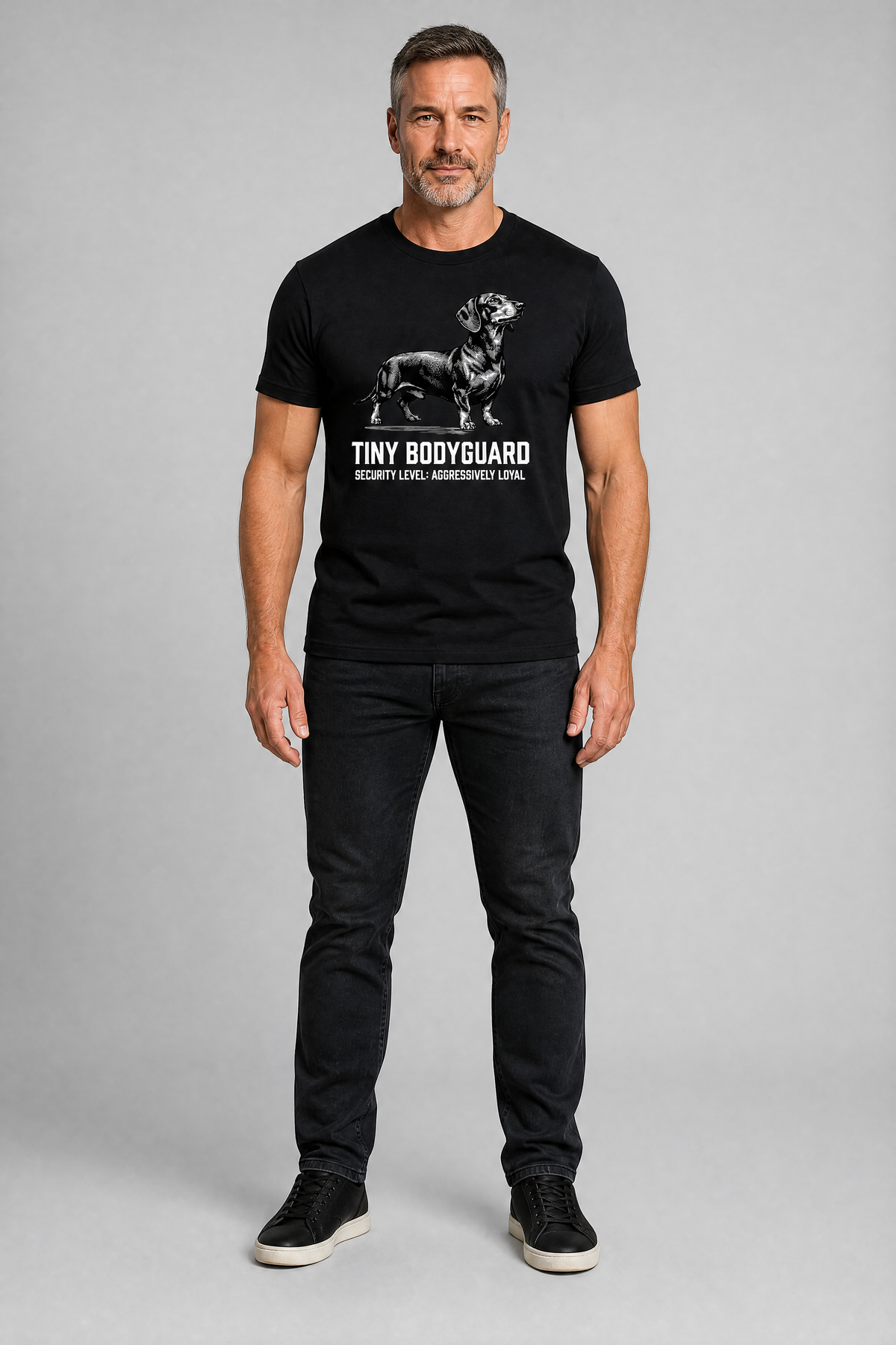 Man wearing a black t-shirt with a graphic design on a gray background