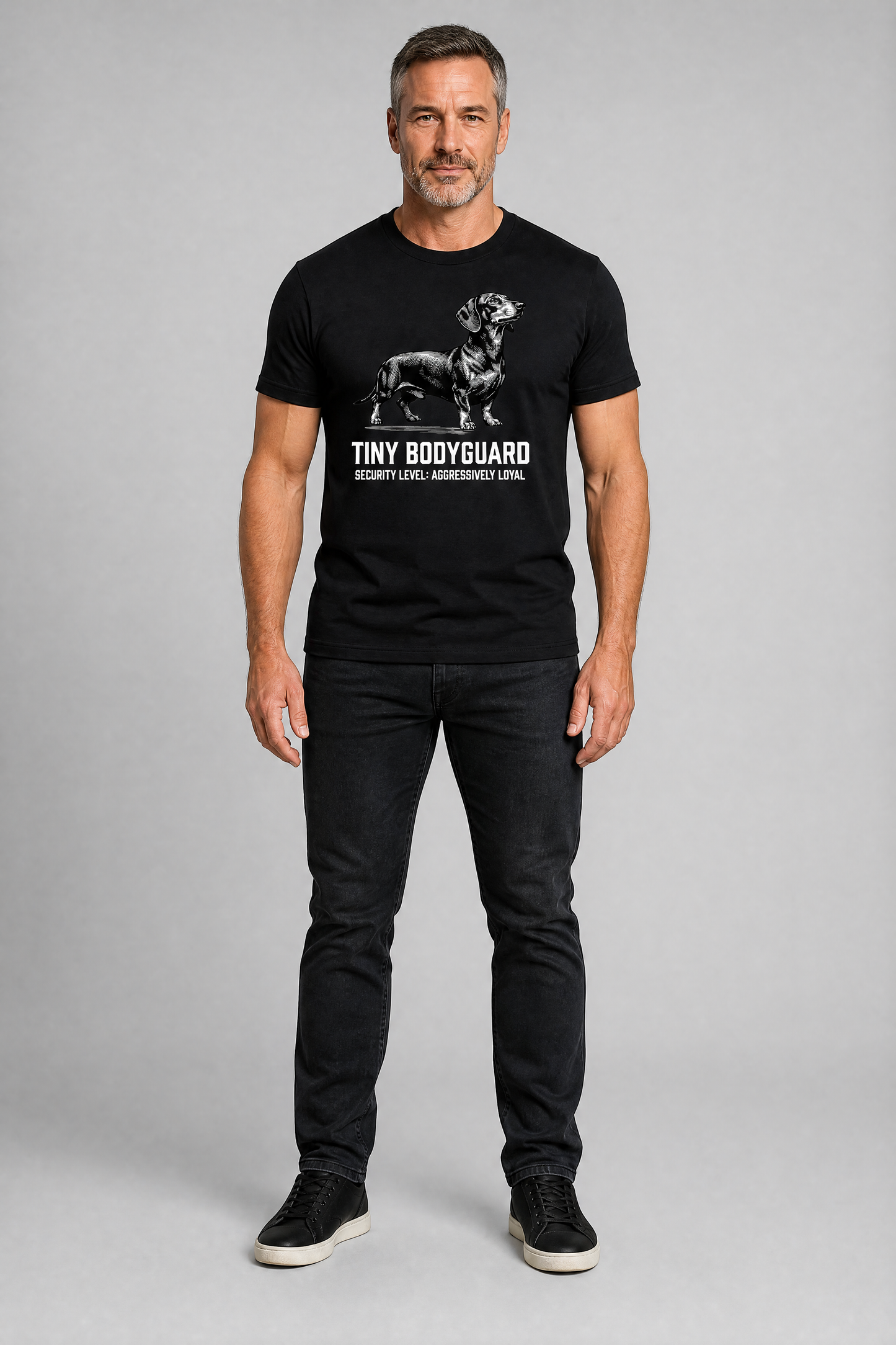 Man wearing a black t-shirt with a graphic design on a gray background