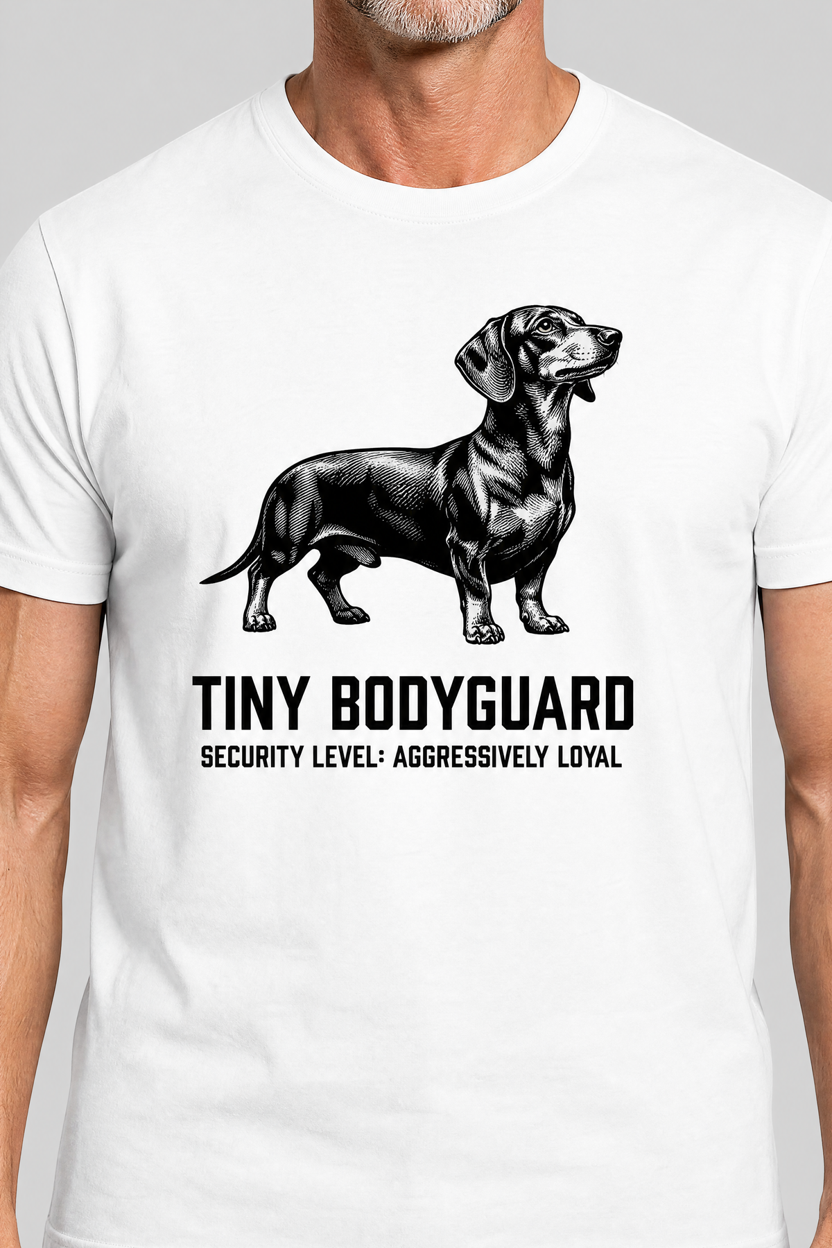 White t-shirt with a dachshund graphic and text on a gray background