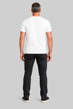 Man wearing a white t-shirt and black jeans on a gray background