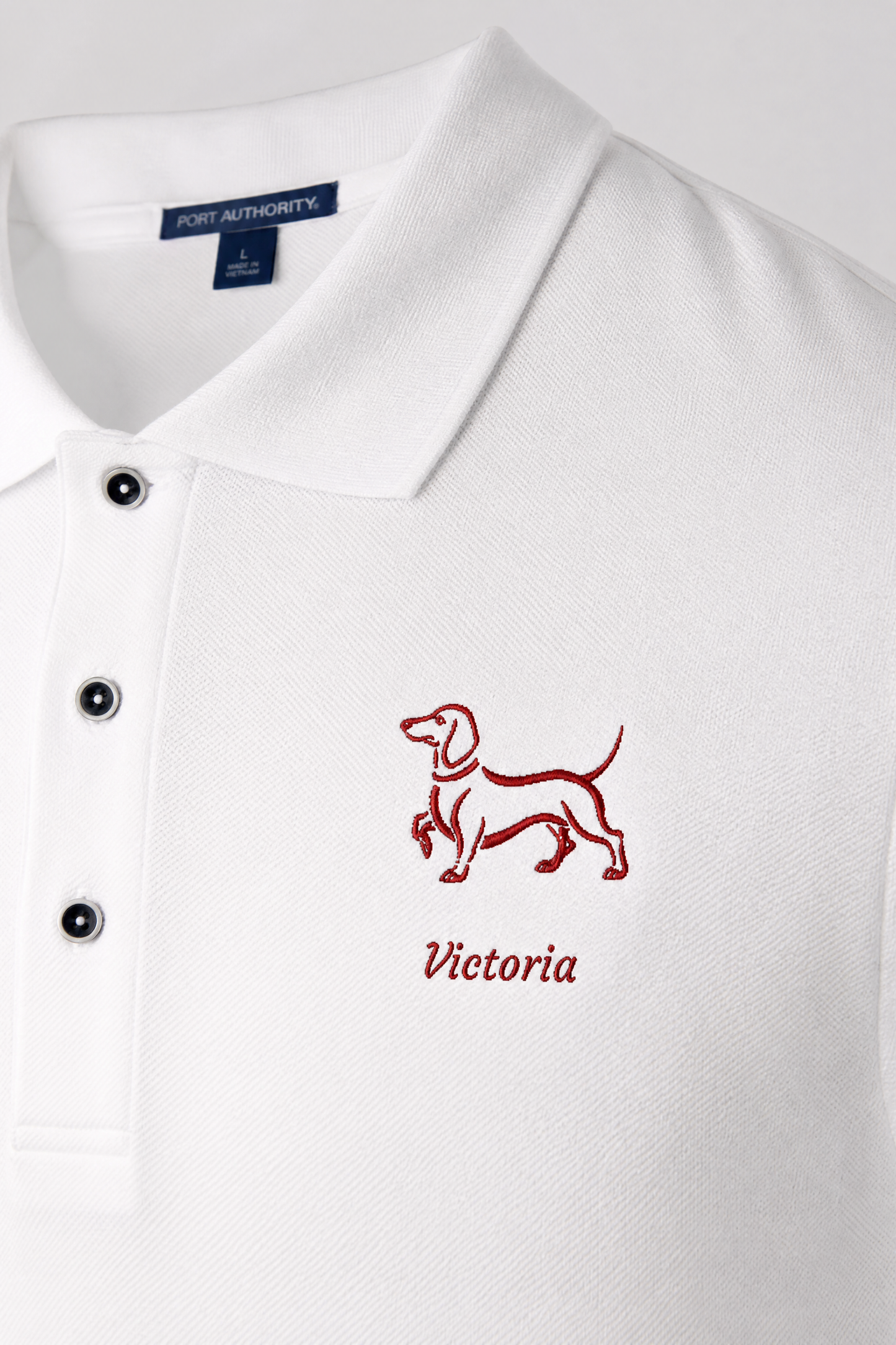 Man wearing white embroidered dachshund polo shirt with personalized dog name in red thread
