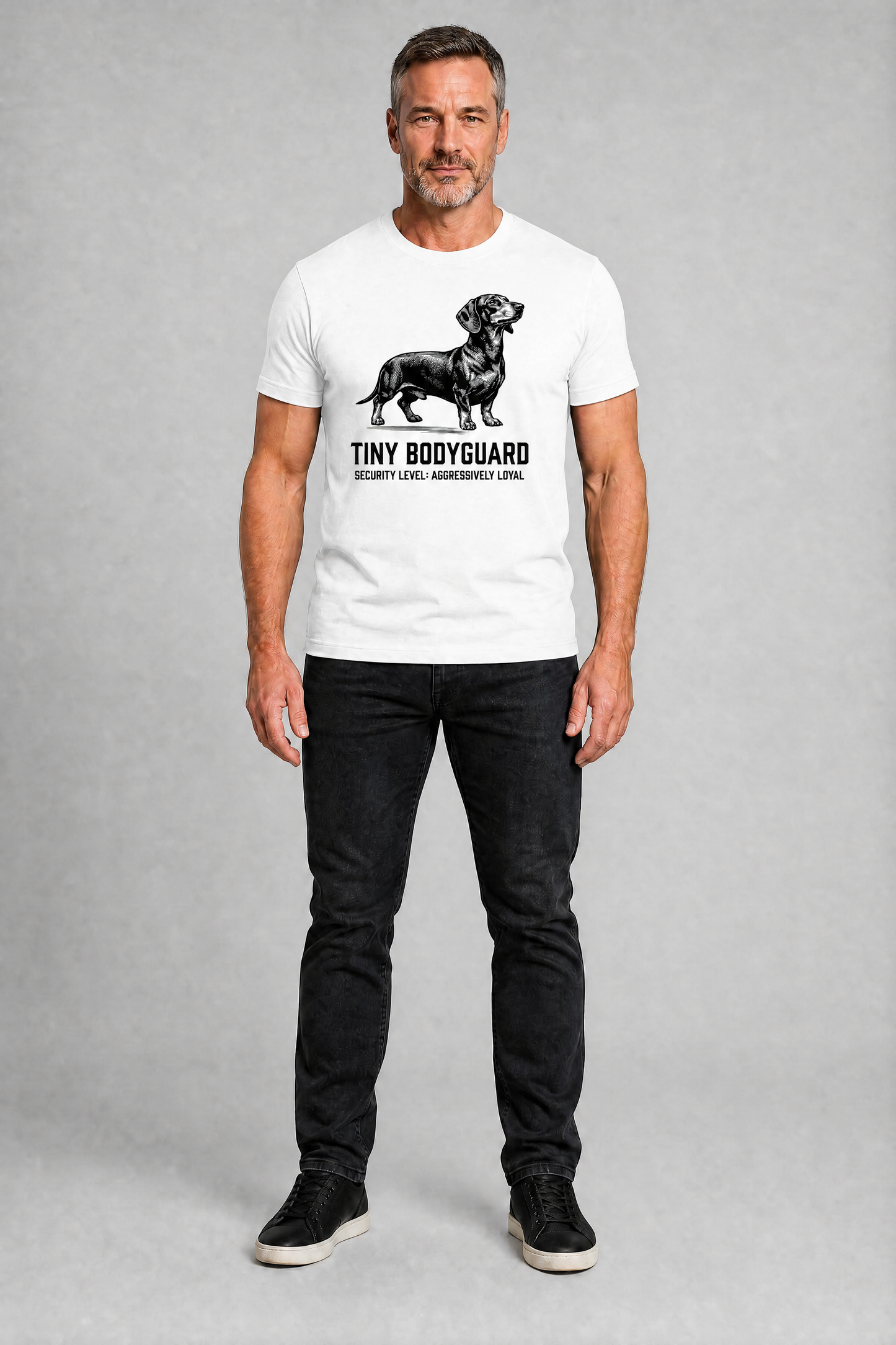 Man wearing a white t-shirt with a dachshund graphic and text on a gray background
