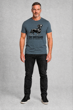 Man wearing a gray t-shirt with a graphic and text, standing against a plain background
