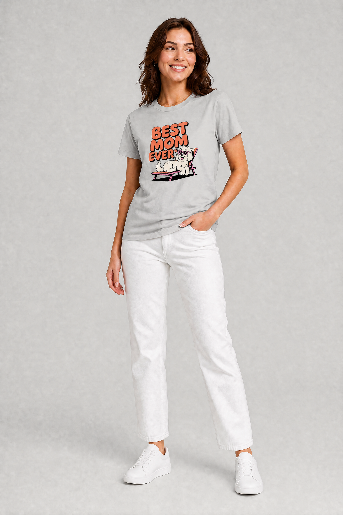 Woman wearing a gray t-shirt with a graphic design and text, standing against a plain background