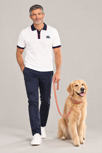 Man in the white Club Crest color block polo with a Golden Retriever on the peach Cloud 7 Tiergarten leash and collar