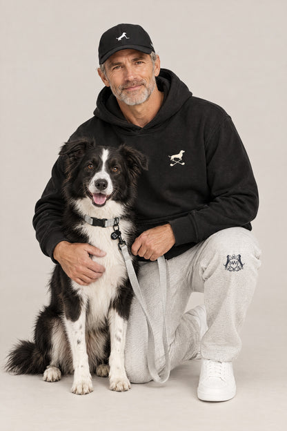 Man in the black Club & Swing Dachshund golf hoodie hugging a rescue dog wearing the Cloud 7 RESC7UE Silver collar and leash