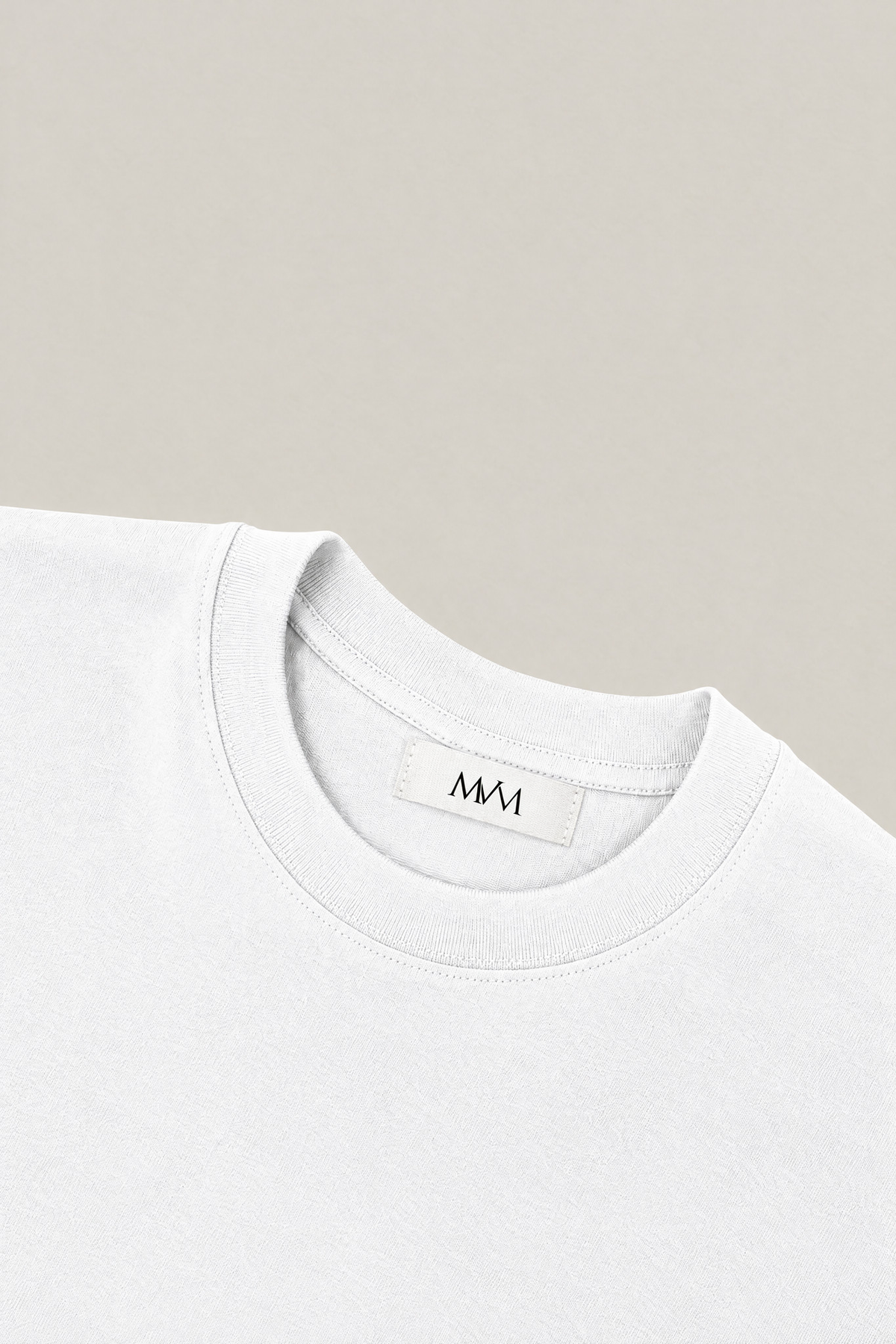 Ribbed crew neck of the white heavyweight cotton tee with the MVM woven neck label, close-up. Color: White