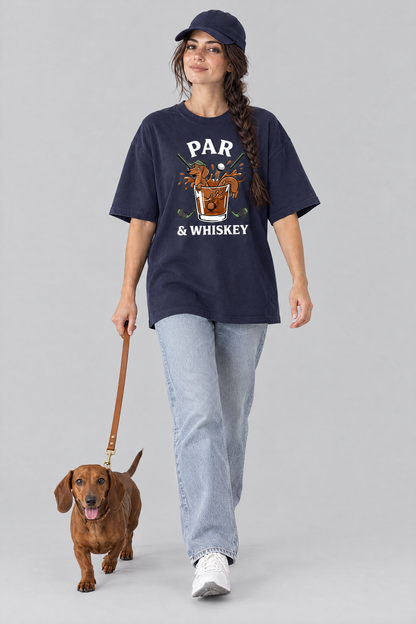 Woman walking a red dachshund on a leash in the navy Par & Whiskey Dachshund Golf Tee with light blue jeans and a navy cap. Color: Navy