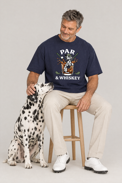Man sitting on a stool with a Dalmatian dog in the navy Par & Whiskey Dalmatian Golf Tee. Color: Navy