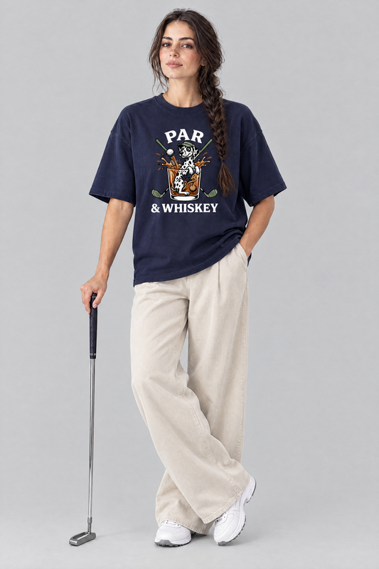 Woman holding a putter in the navy Par & Whiskey Dalmatian Golf Tee with stone wide-leg trousers. Color: Navy