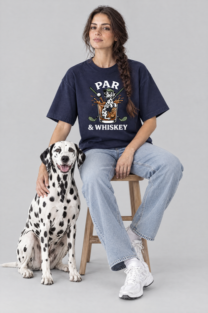 Woman sitting on a stool with a Dalmatian dog in the navy Par & Whiskey Dalmatian Golf Tee. Color: Navy