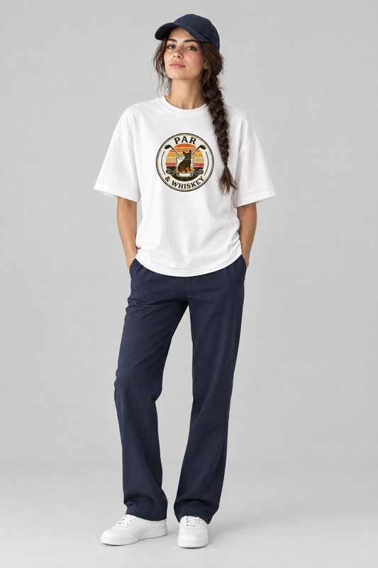 Woman wearing the Par & Whiskey French Bulldog Badge Golf Tee in white with navy trousers and a navy cap. Color: White
