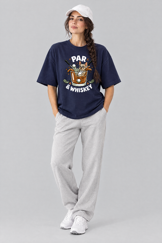 Woman wearing the Par & Whiskey French Bulldog Splash Golf Tee in navy with light grey trousers and a white cap. Color: Navy
