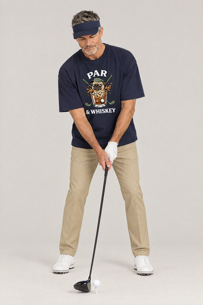 Man addressing the ball with a driver in the navy Par & Whiskey Pug Golf Tee. Color: Navy