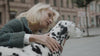 Stylish dog owner with Dalmatian wearing a matching premium dog collar and leash set.