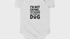 Smiling baby wearing a funny dog-themed baby bodysuit with pet lover quote.
