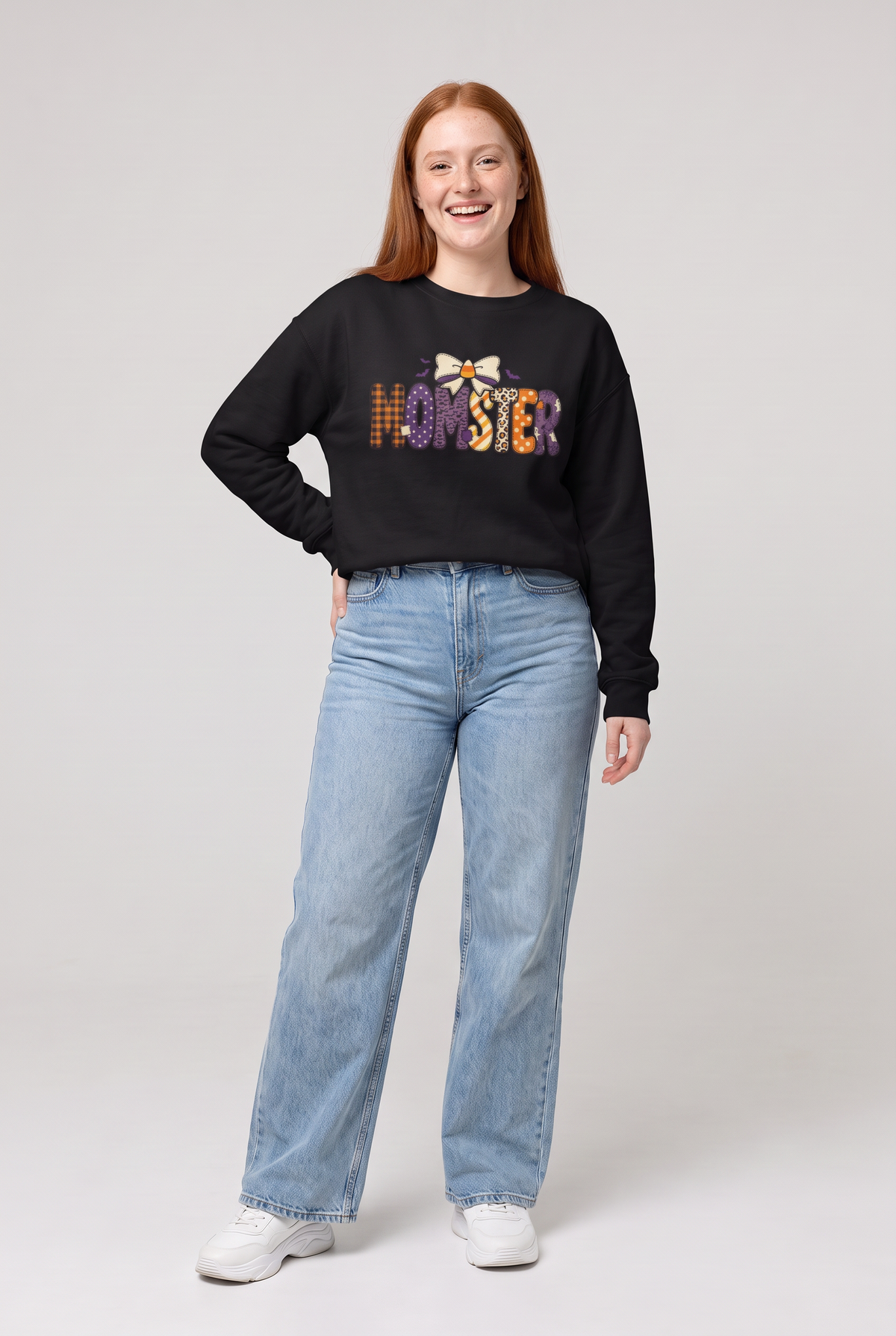 Woman wearing the Momster Halloween sweatshirt in black, three-quarter view. Color: Black