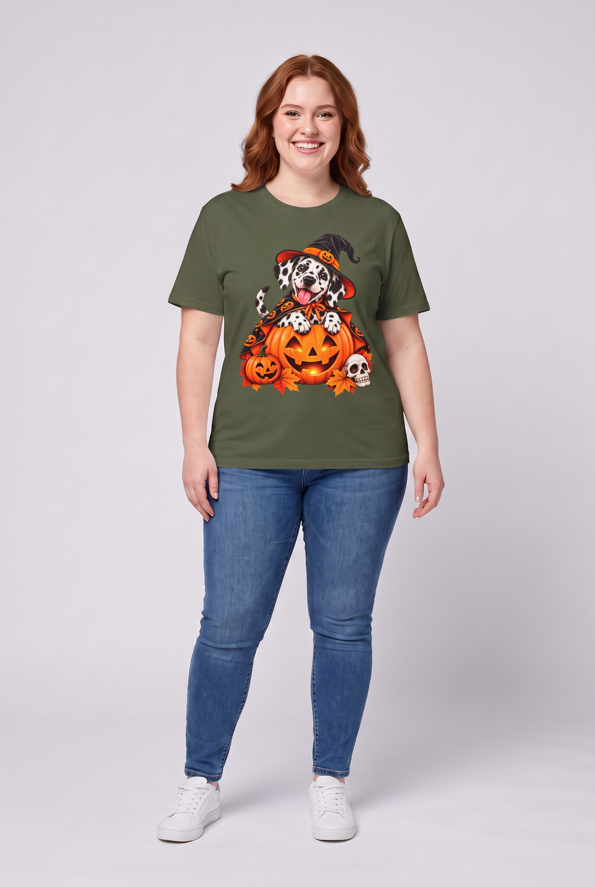 Frau trägt ein Dalmatiner Hexen Halloween T-Shirt in Military Green mit Dalmatiner in Hexenhut und Kürbis-Umhang auf einer Kürbislaterne, Vorderansicht