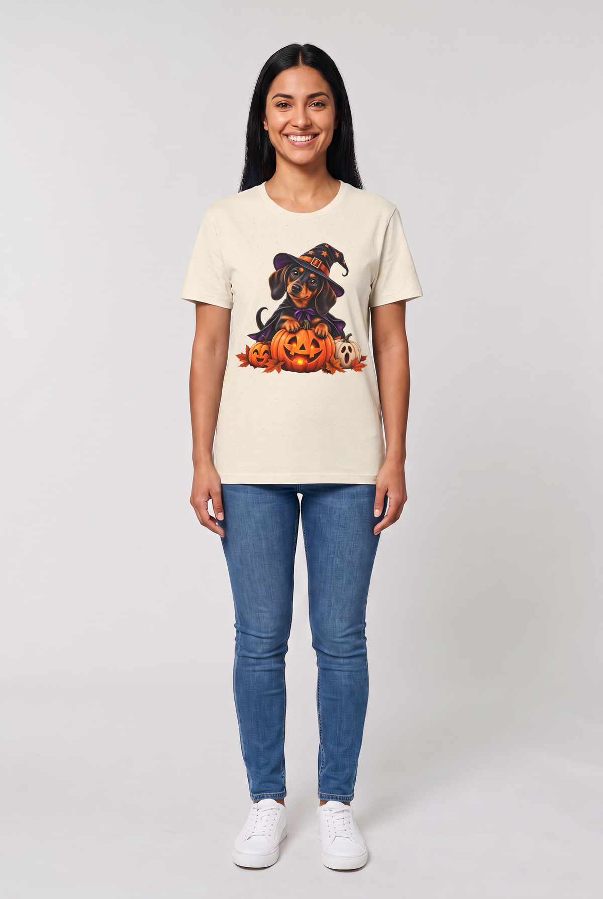 Frau trägt ein Dackel Hexen Halloween T-Shirt in Natural mit Dackel in Hexenhut und Umhang auf einer leuchtenden Kürbislaterne, Vorderansicht