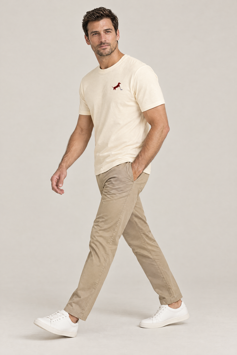 Man walking in apricot Putting dachshund golf t-shirt and khaki chinos, side view. Color: Apricot