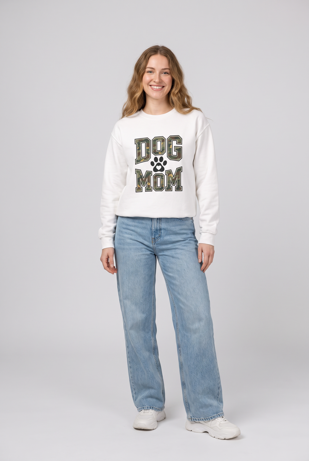 Woman wearing the Camo Dog Mom sweatshirt in white, front view. Color: White