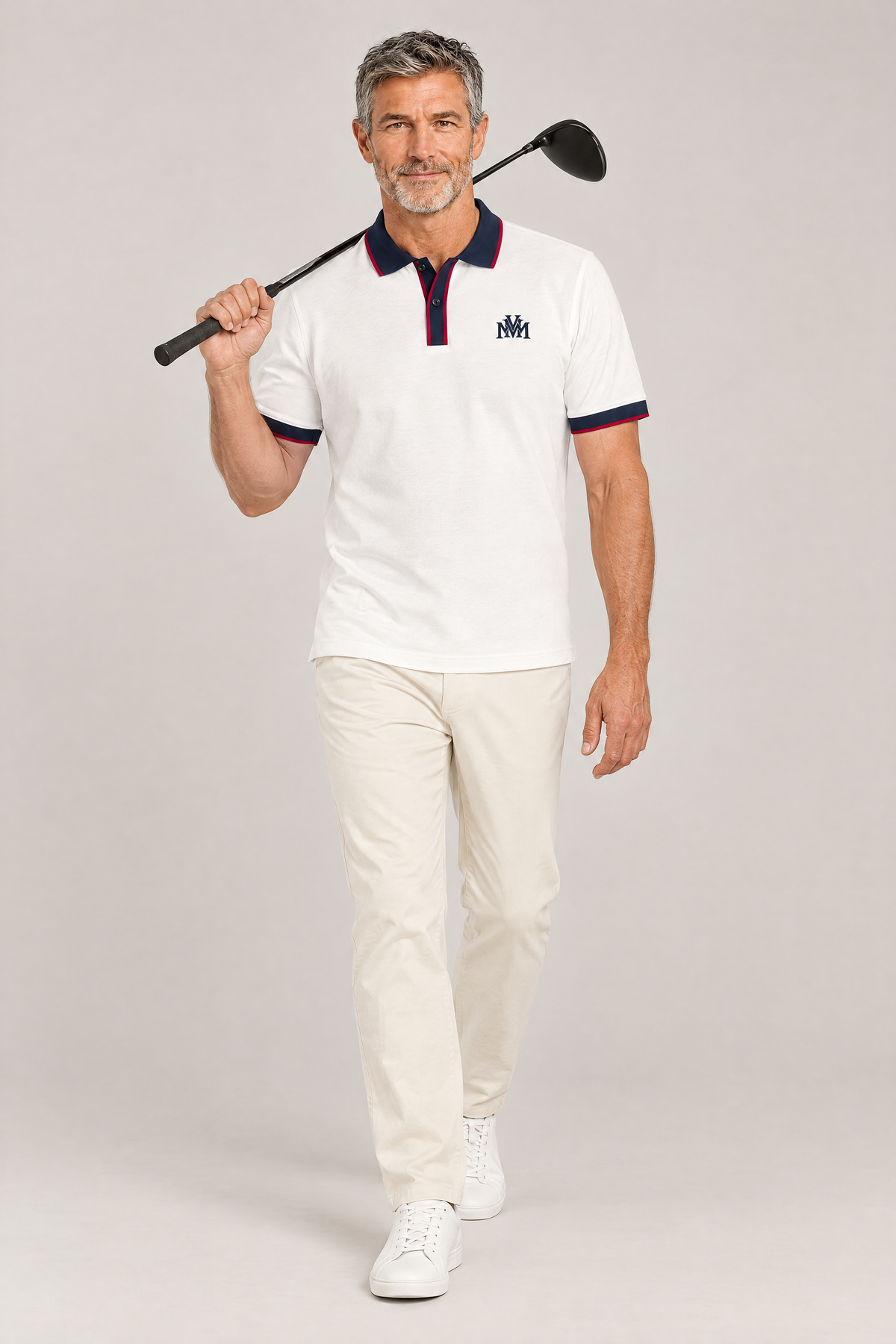 Man walking toward the camera in the white Club Crest polo with navy trim, driver over his shoulder. Color: White with Navy Blue