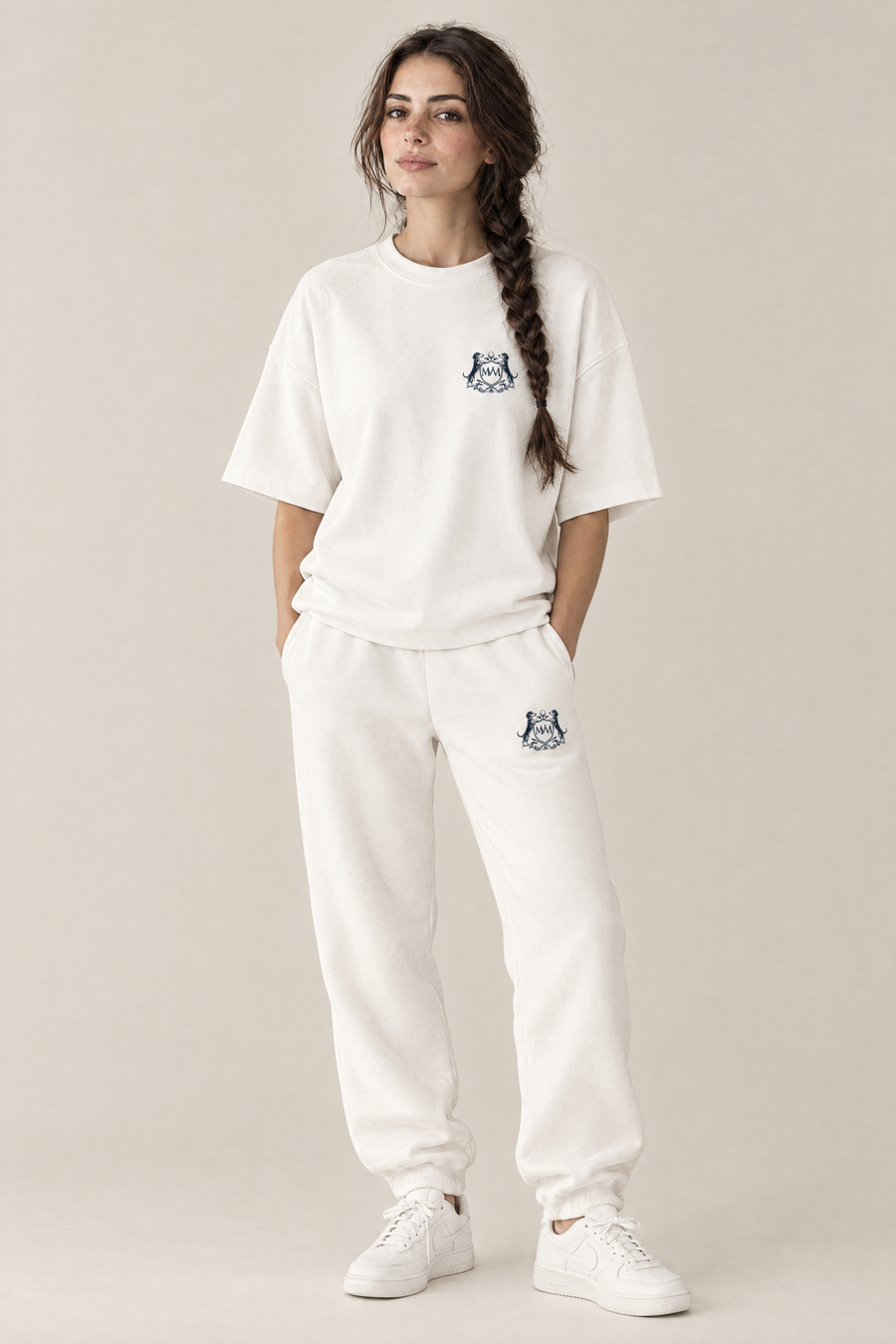 Woman in a white oversized Club Crest tee and matching white sweatpants, full body, tone-on-tone set