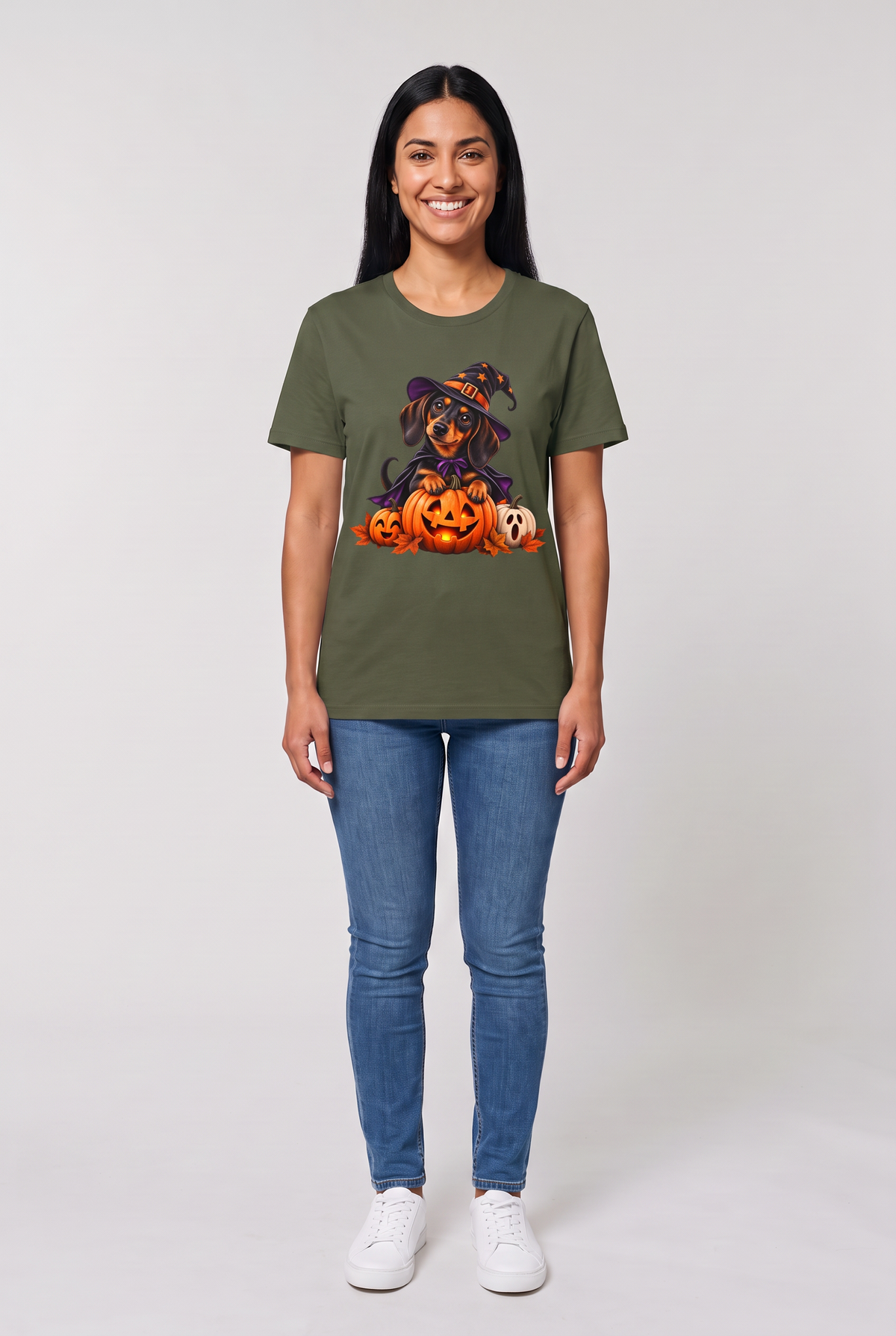 Frau trägt ein Dackel Hexen Halloween T-Shirt in Military Green mit Dackel in Hexenhut und Umhang auf einer leuchtenden Kürbislaterne, Vorderansicht