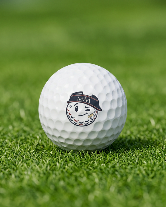 Mulligan golf ball in navy and burgundy print, close-up on green grass