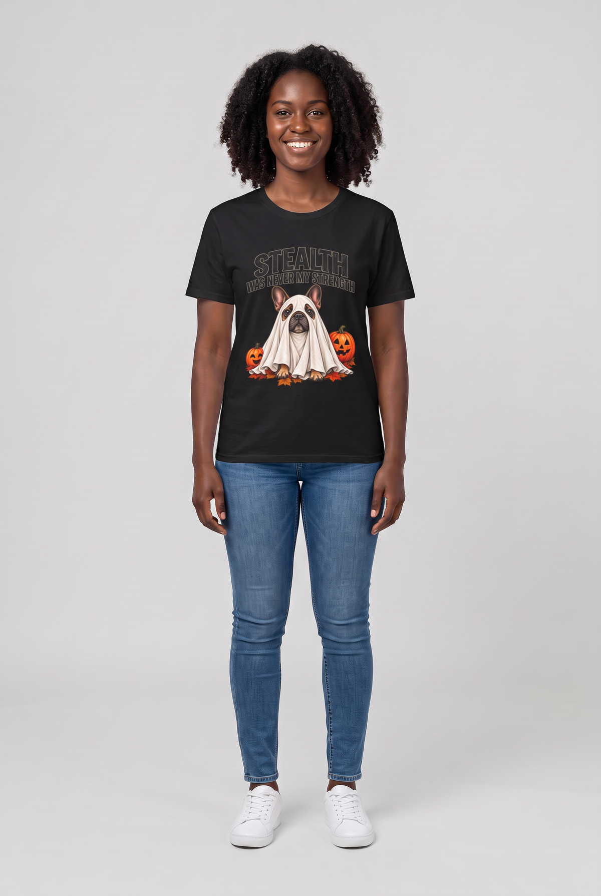 Frau trägt ein Französische Bulldogge Halloween T-Shirt in Schwarz mit Frenchie-Gespenst und dem Spruch Stealth Was Never My Strength, Vorderansicht